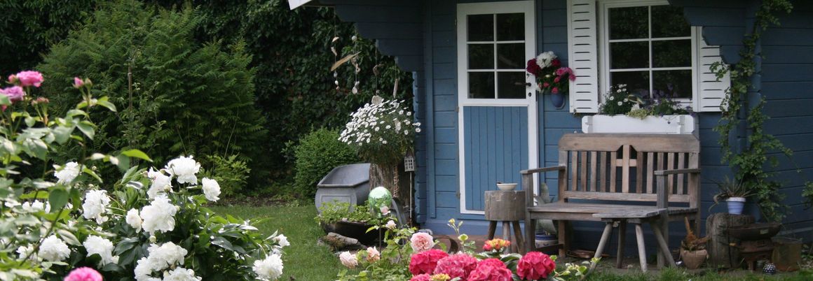 Blaues Gartenhaus steht im Garten